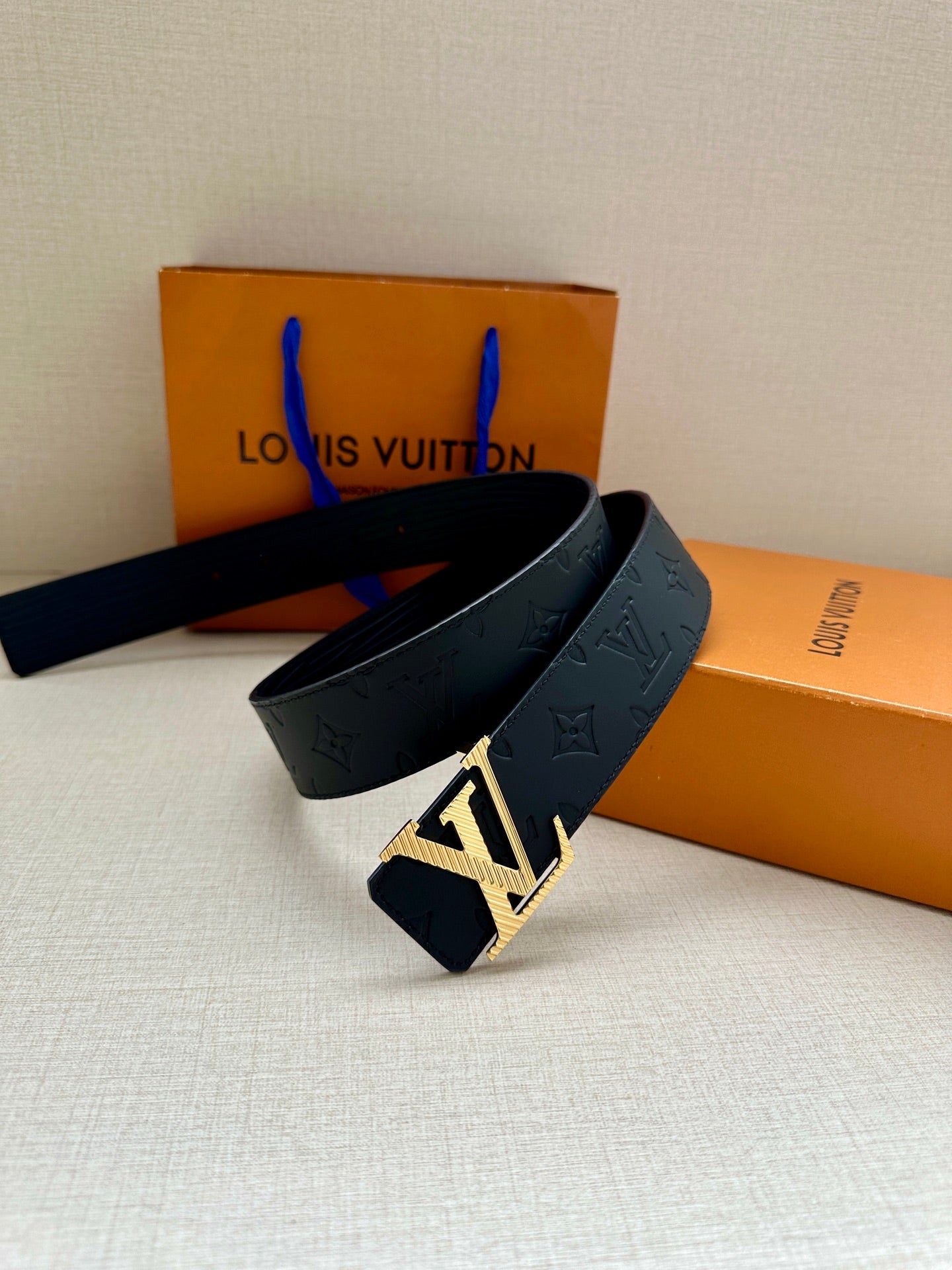 Louis Vuitton leather belt with gold buckle, dark blue on display