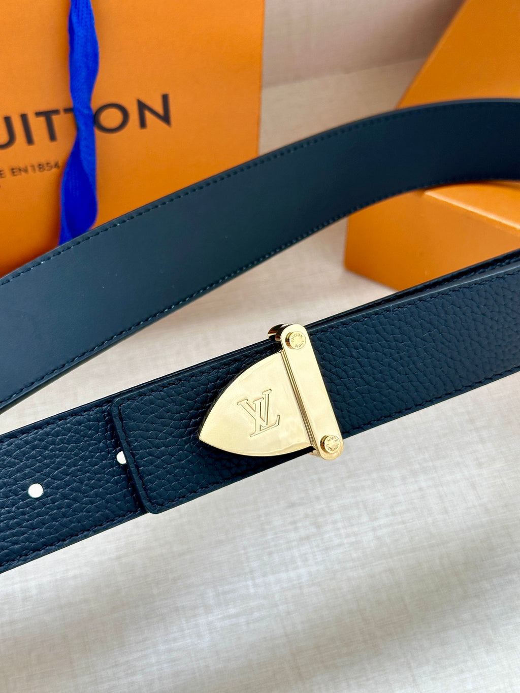 Louis Vuitton belt detail in dark blue leather with gold-tone rectangular buckle