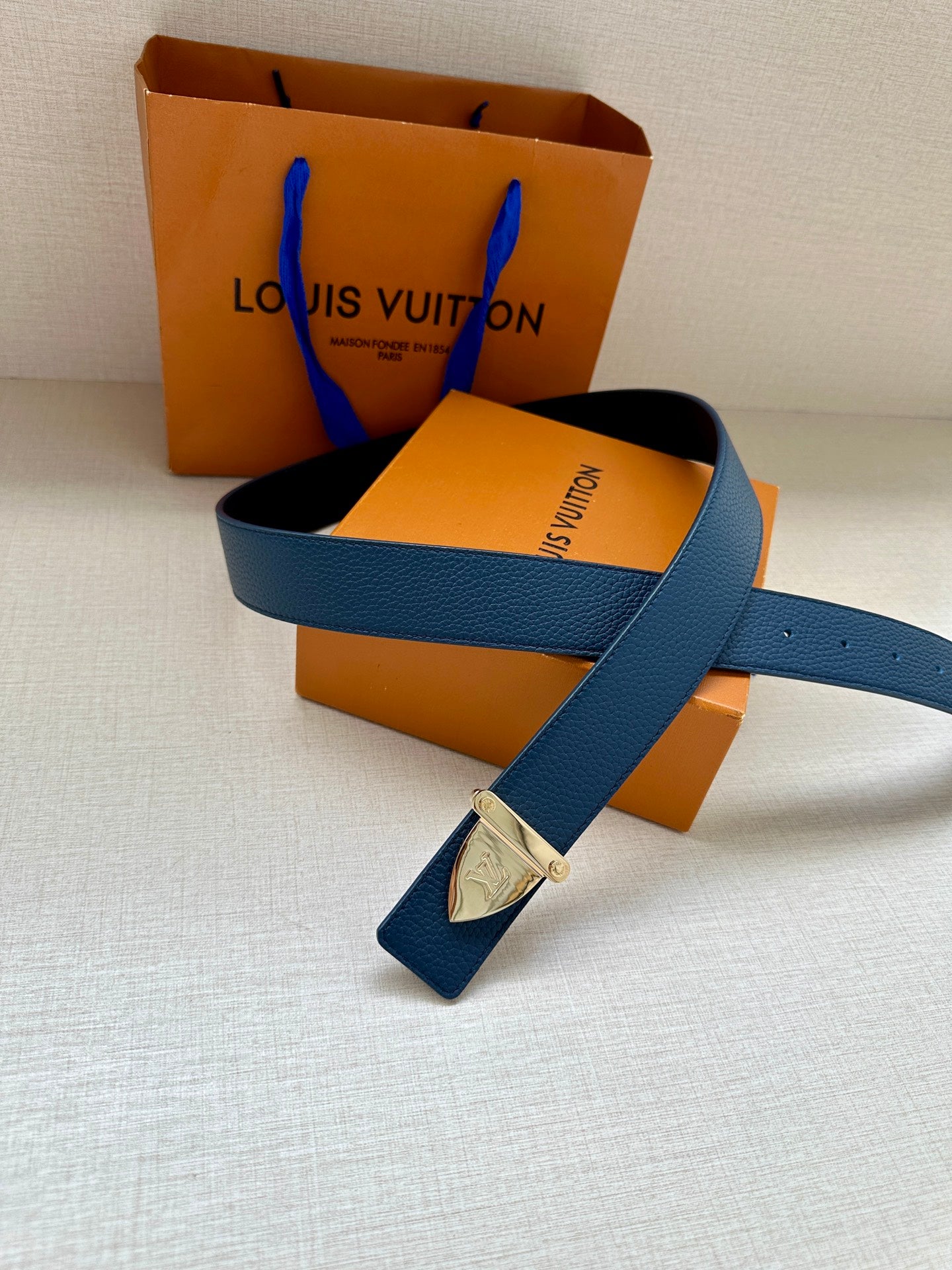 Blue leather belt with silver buckle and small matching leather tag