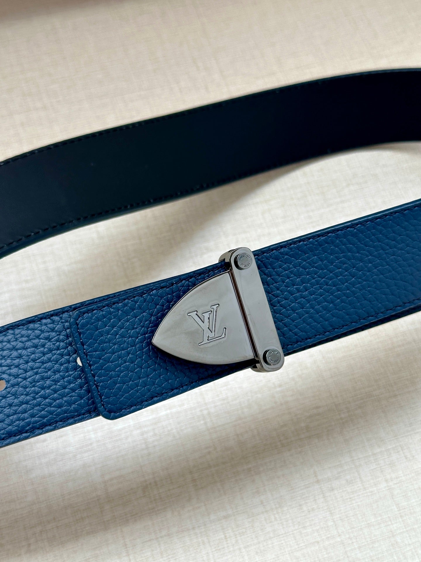 Blue leather belt strap with silver rectangular buckle and LV emblem