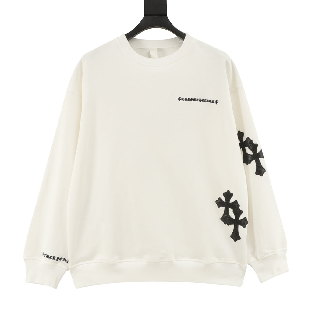 Cream long-sleeve crewneck sweatshirt with black cross patches on sleeves