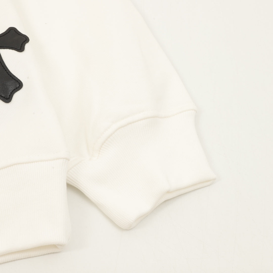 Cream sweatshirt sleeve cuffs with black appliqué cross details