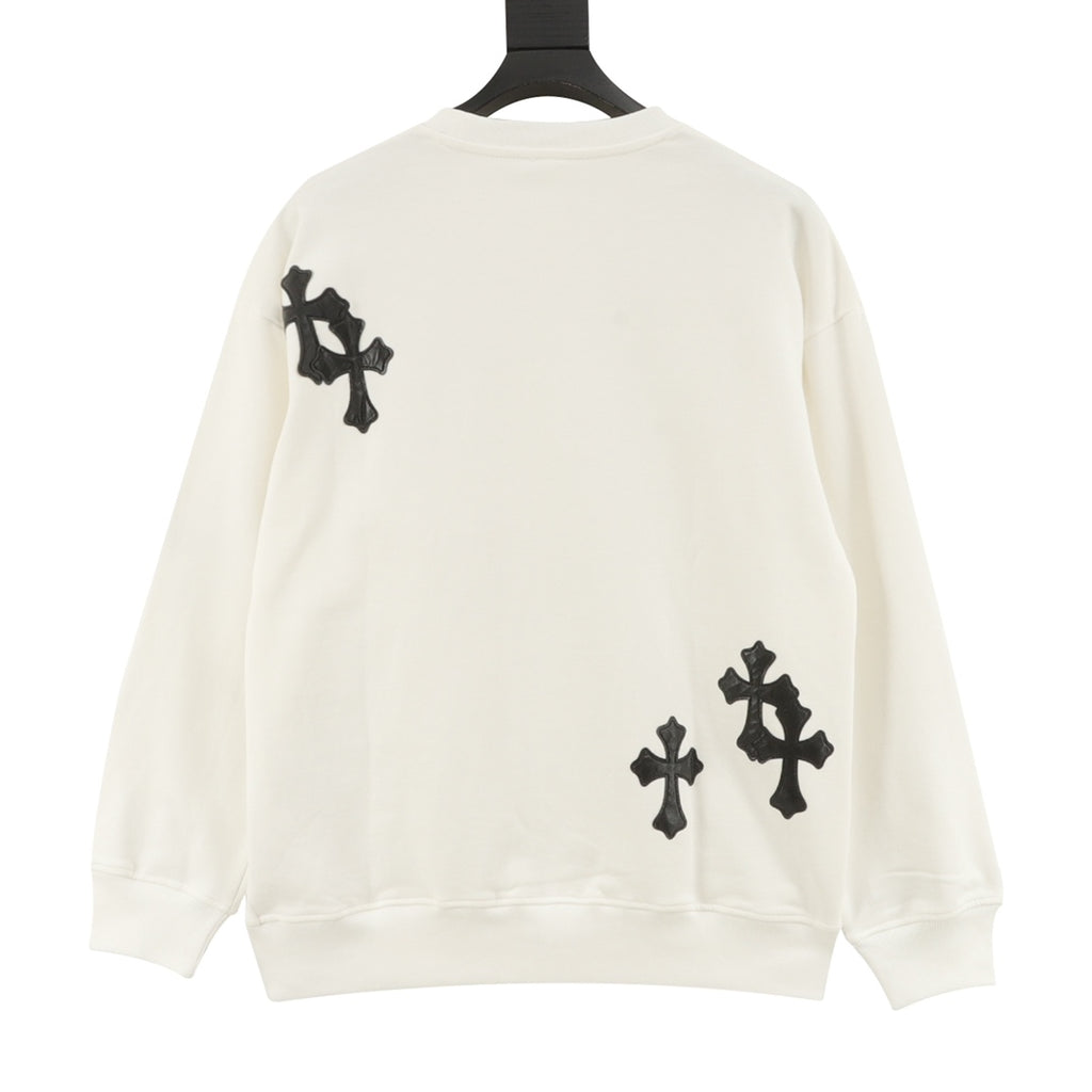 Cream crewneck sweatshirt with black cross patches on back shoulders and lower hem