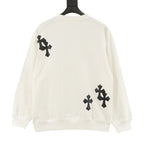 Cream crewneck sweatshirt with black cross patches on back shoulders and lower hem