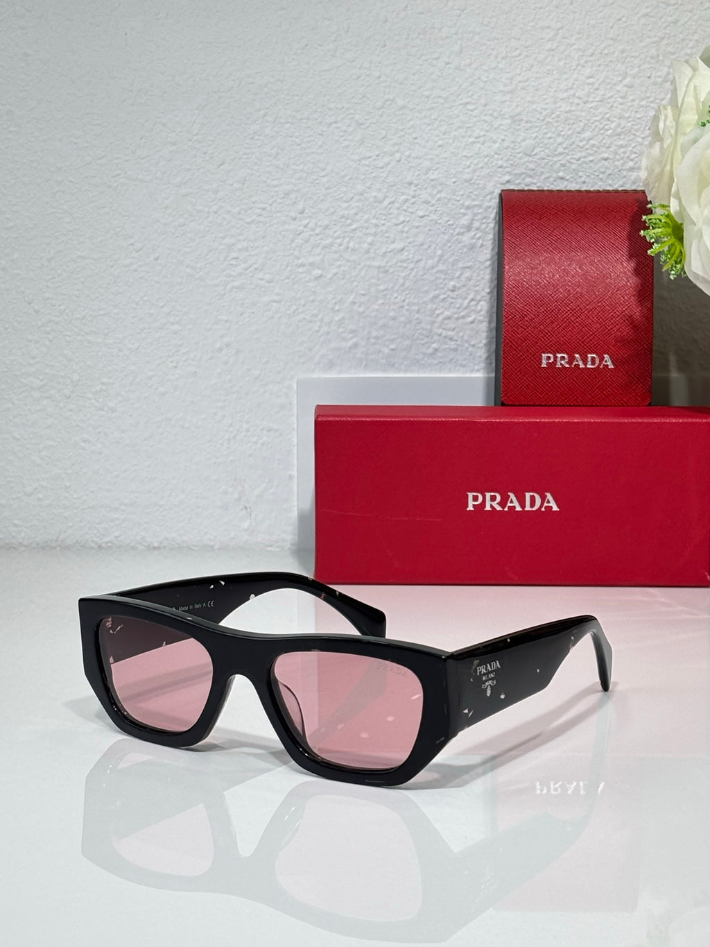 Prada black cat-eye sunglasses with rosy lenses