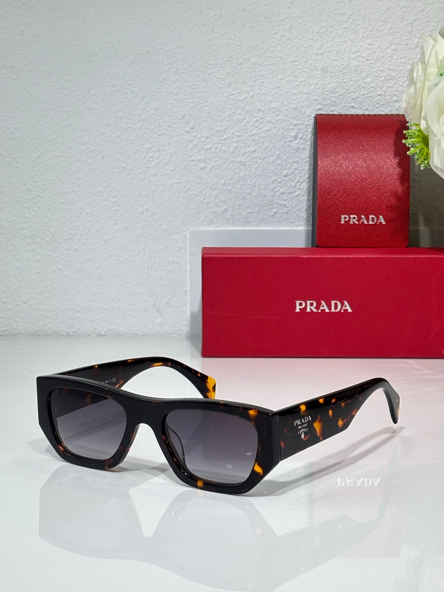Prada black cat-eye sunglasses with gray lenses and tortoise arms