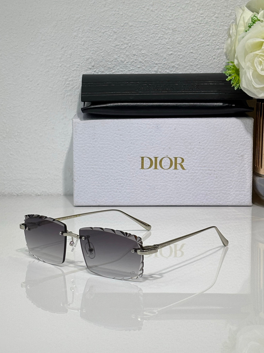 Dior sunglasses with dark tinted lenses, slim gold-tone frame and clear arms