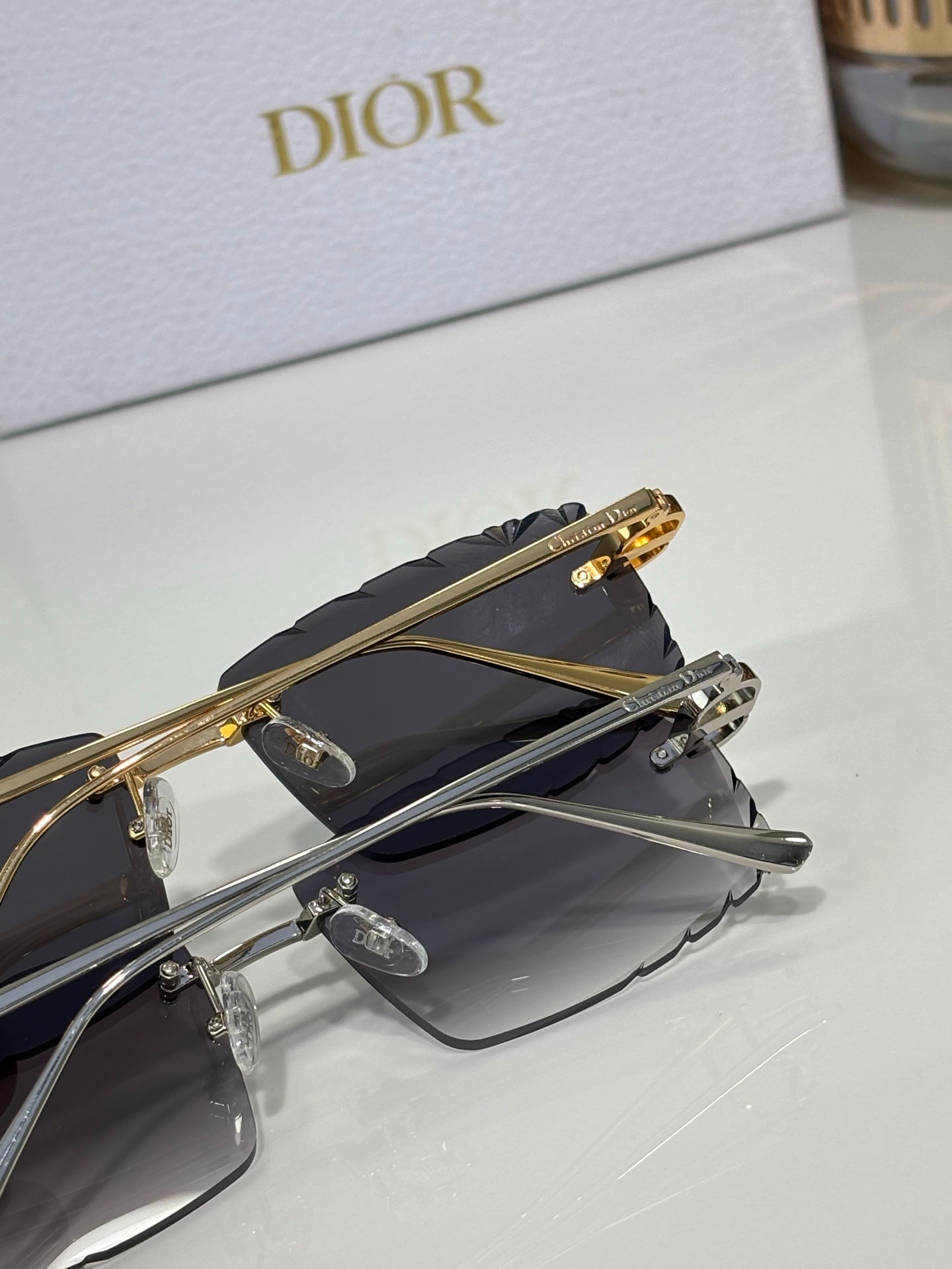 Dior sunglasses in dark tone, showing gold hinge hardware and temple details