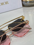 Sunglasses close-up with dark lenses and pink lens cover, gold-tone frame