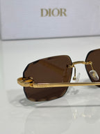 Sunglasses with dark brown tinted lenses and gold-tone metal frame