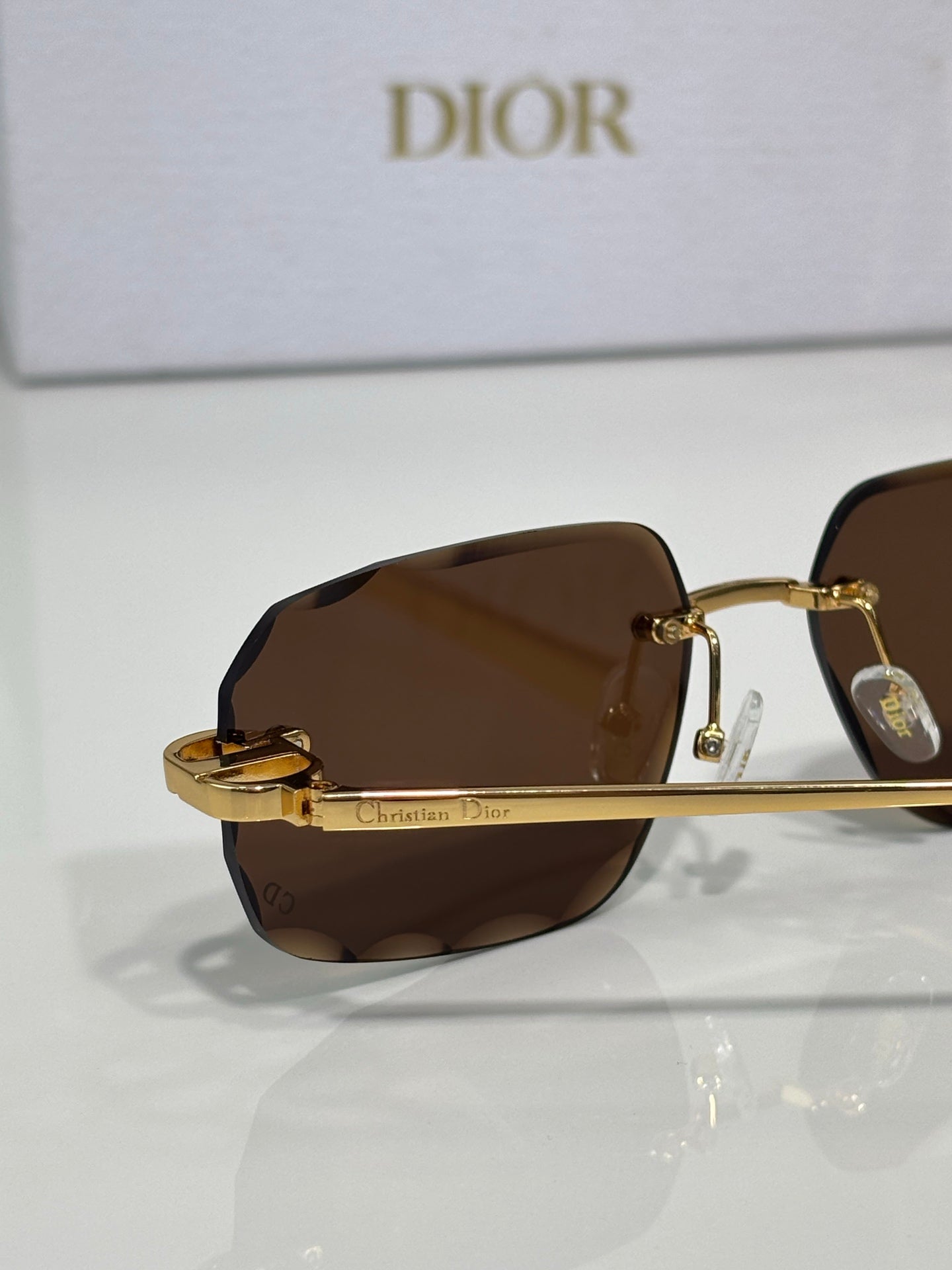 Sunglasses with dark brown tinted lenses and gold-tone metal frame
