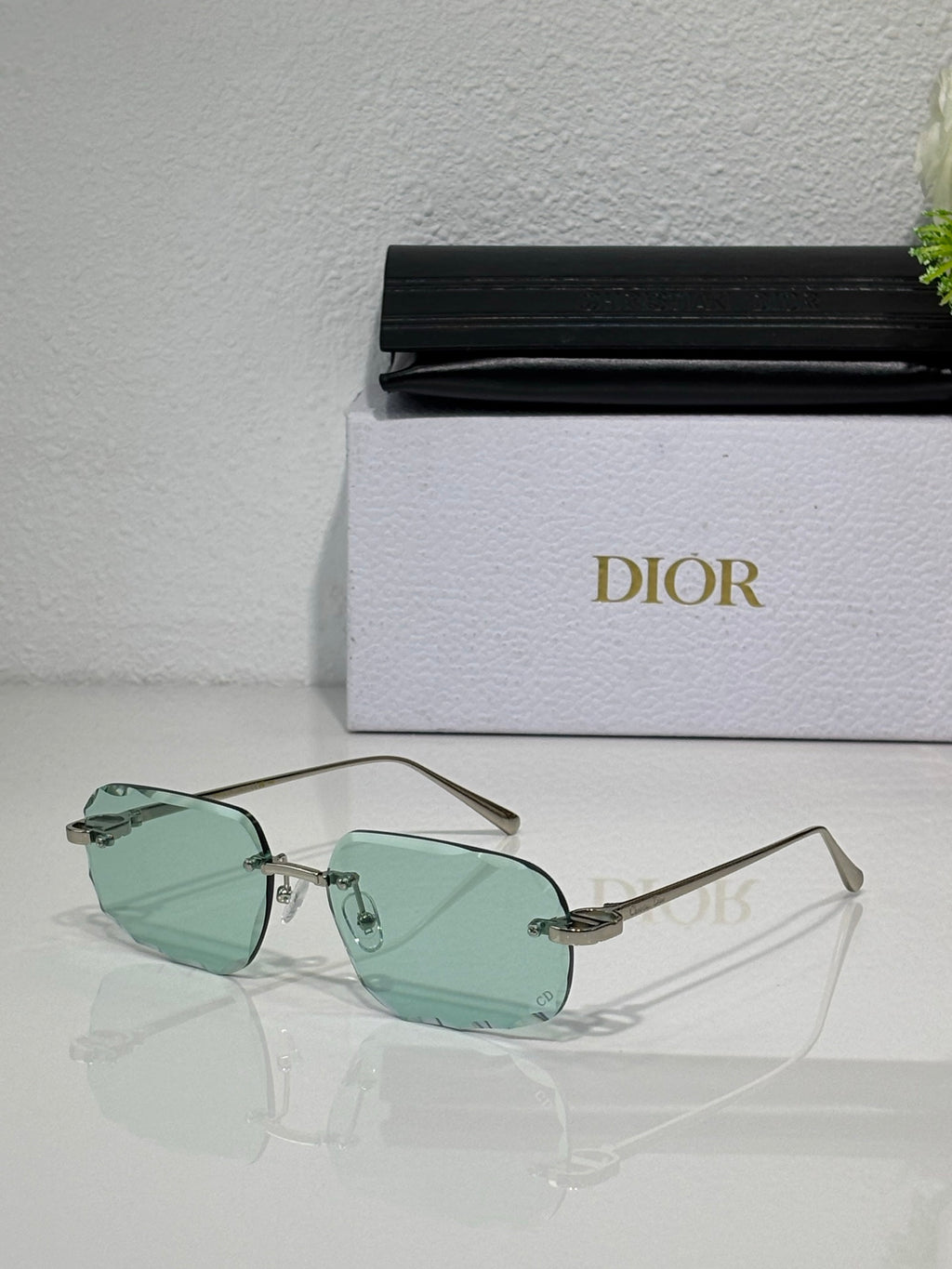 Sunglasses with mint green tinted lenses and thin gold-tone metal frame