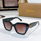Tortoiseshell sunglasses with rose-brown lenses and gold medallion detail on the temples