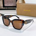 Tortoiseshell sunglasses with brown lenses and gold medallion detail on the temples