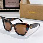 Tortoiseshell sunglasses with brown lenses and gold medallion detail on the temples