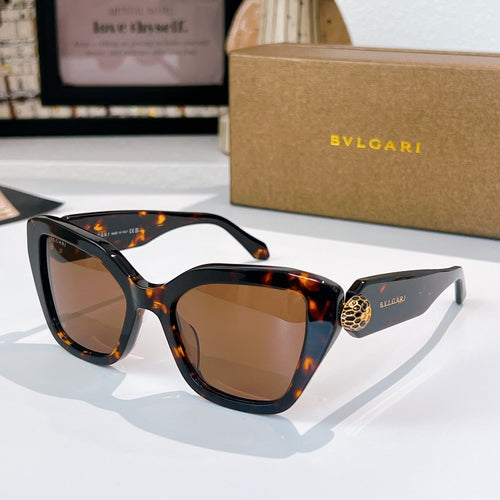 Tortoiseshell sunglasses with brown lenses and gold medallion detail on the temples