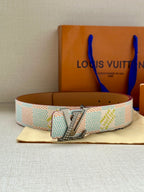 Canvas belt with silver buckle and adjustable tan strap on display