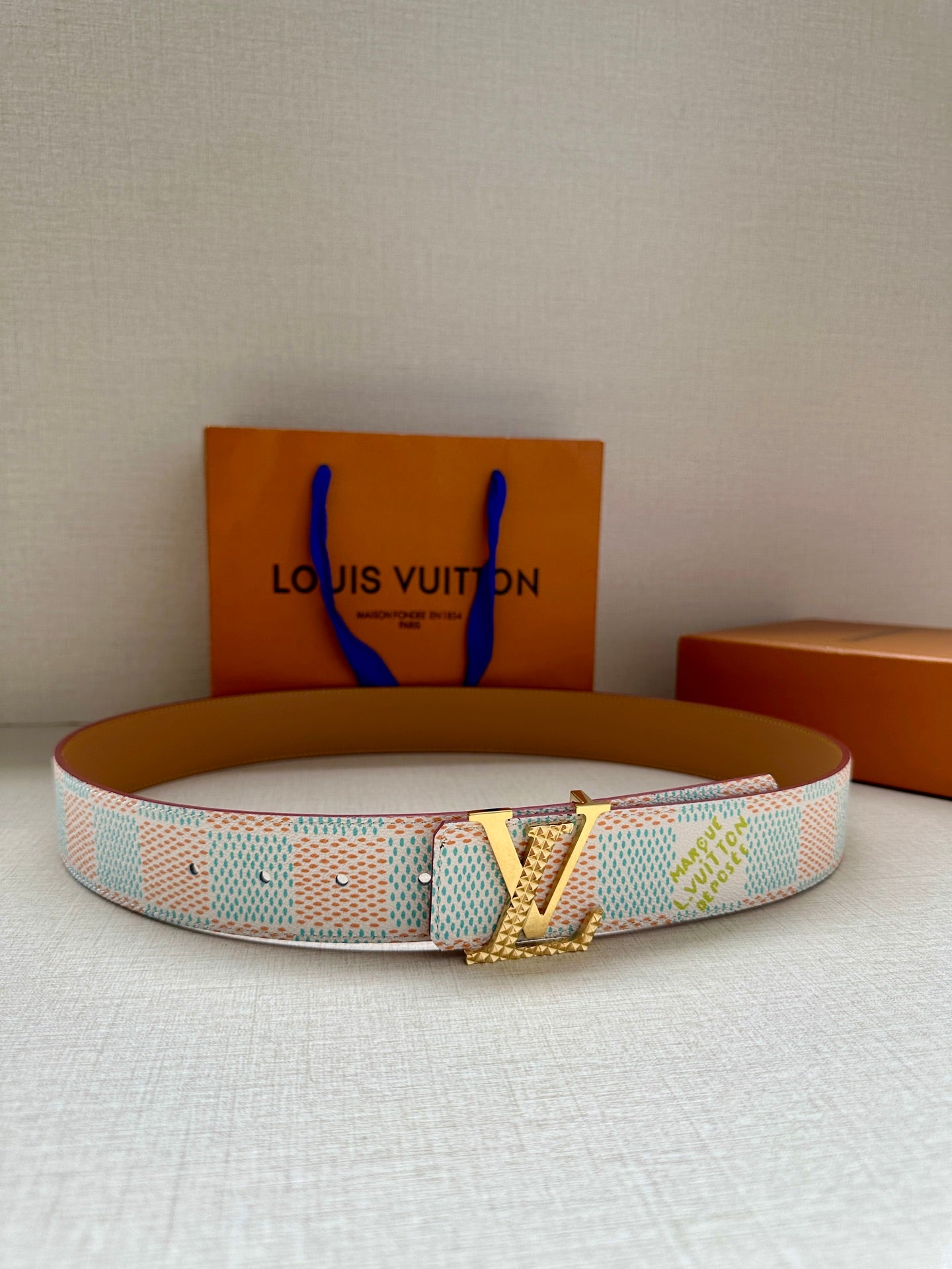 Designer belt in light blue and white canvas with tan holes and silver buckle