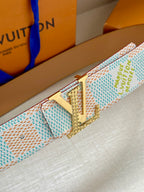 Canvas belt close-up with silver buckle and blue-green monogram pattern