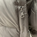 Logo zipper pull on dark puffer jacket lining with stitched panel edges