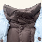 Long puffer jacket front with snap buttons and hood lining, quilted dark fabric