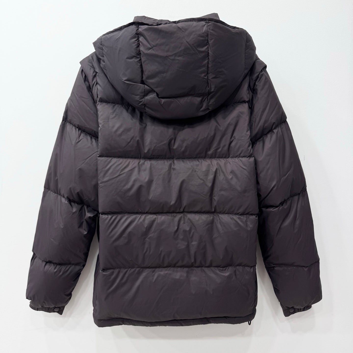 Long dark puffer jacket with hood, quilted back, elastic cuffs and full zip front
