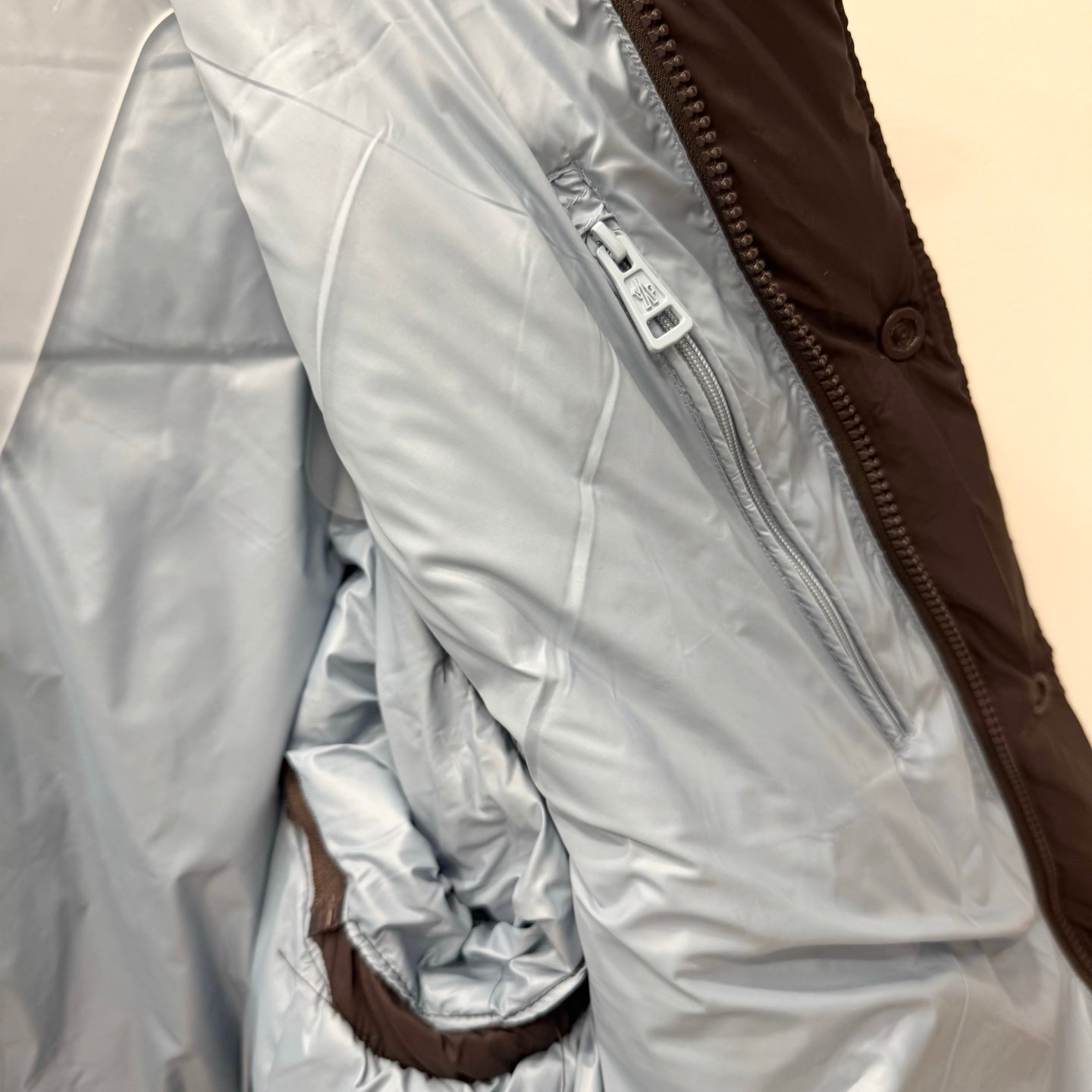White puffer jacket lining with zipper tape detail and stitched seams