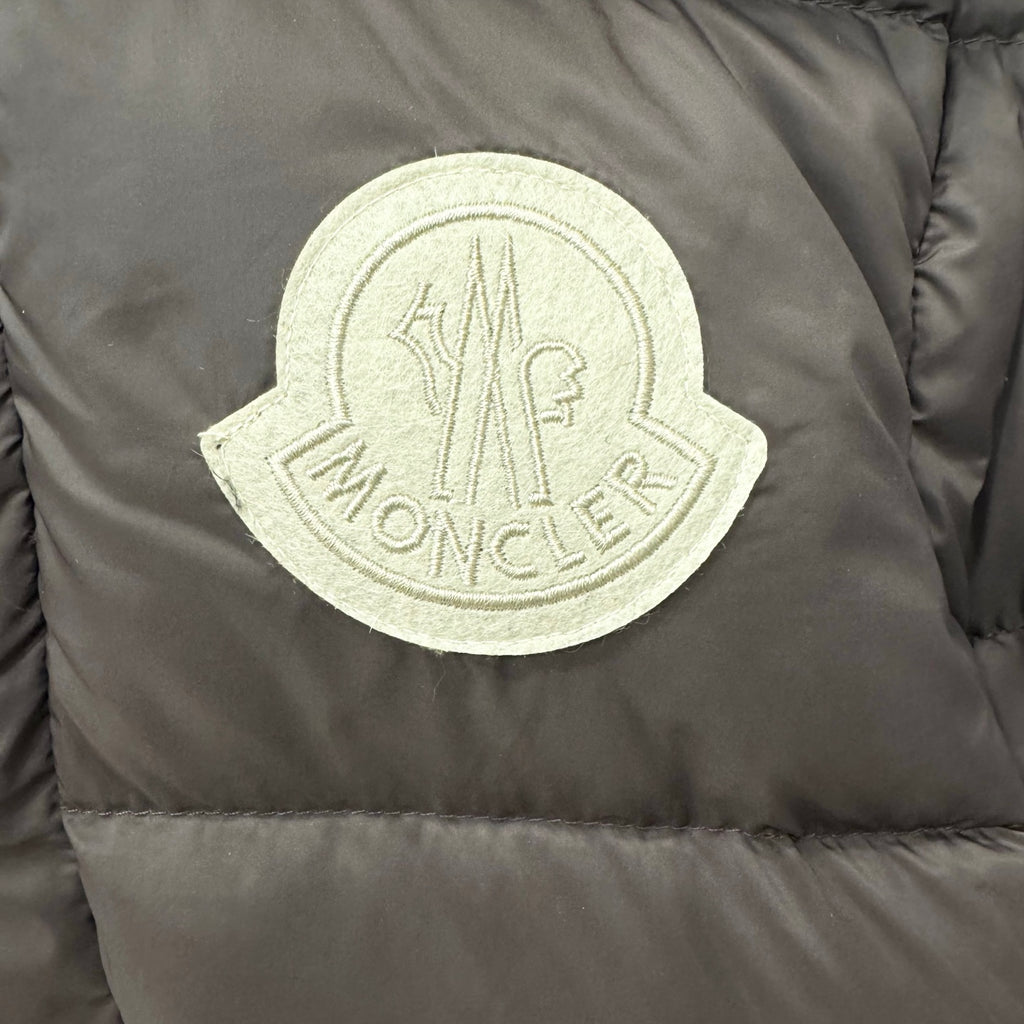 Embroidered logo patch on dark puffer jacket fabric