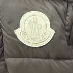 Embroidered logo patch on dark puffer jacket fabric