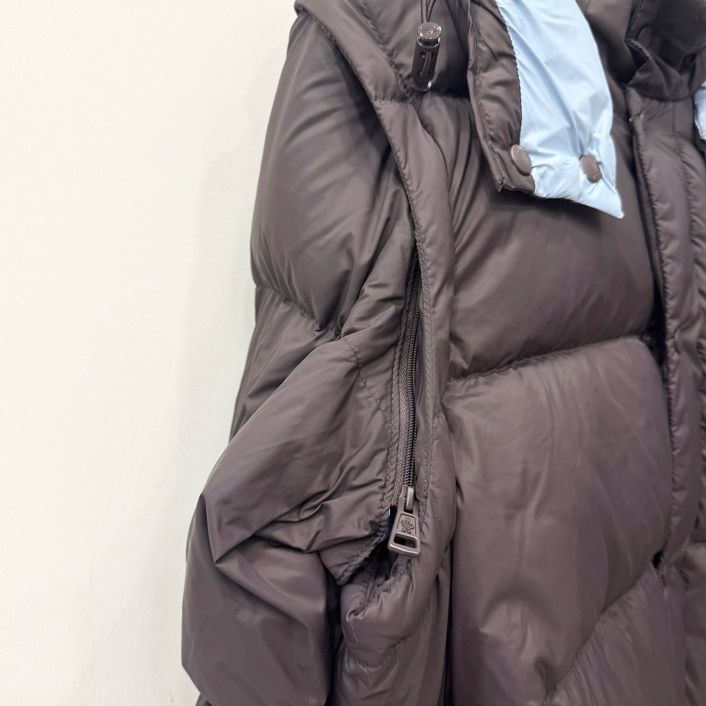 Long dark puffer jacket with hood, full zipper, and quilted body panels