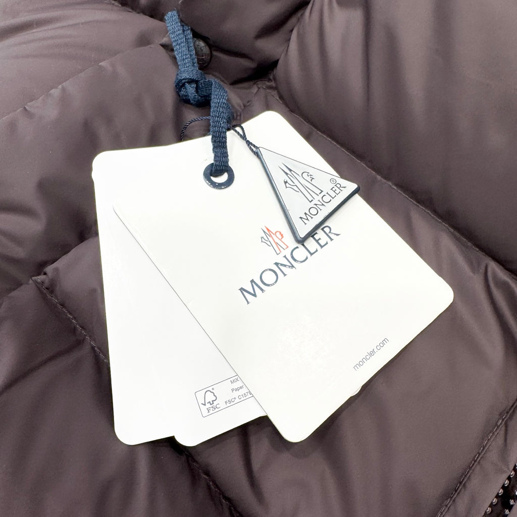 Moncler long coat with quilted shell and hanging brand tags