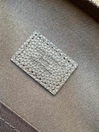 Louis Vuitton dark leather inner label with embossed text on textured fabric