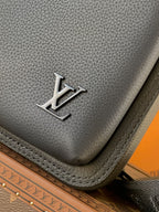 Louis Vuitton dark leather bag corner with silver LV logo and textured grain finish