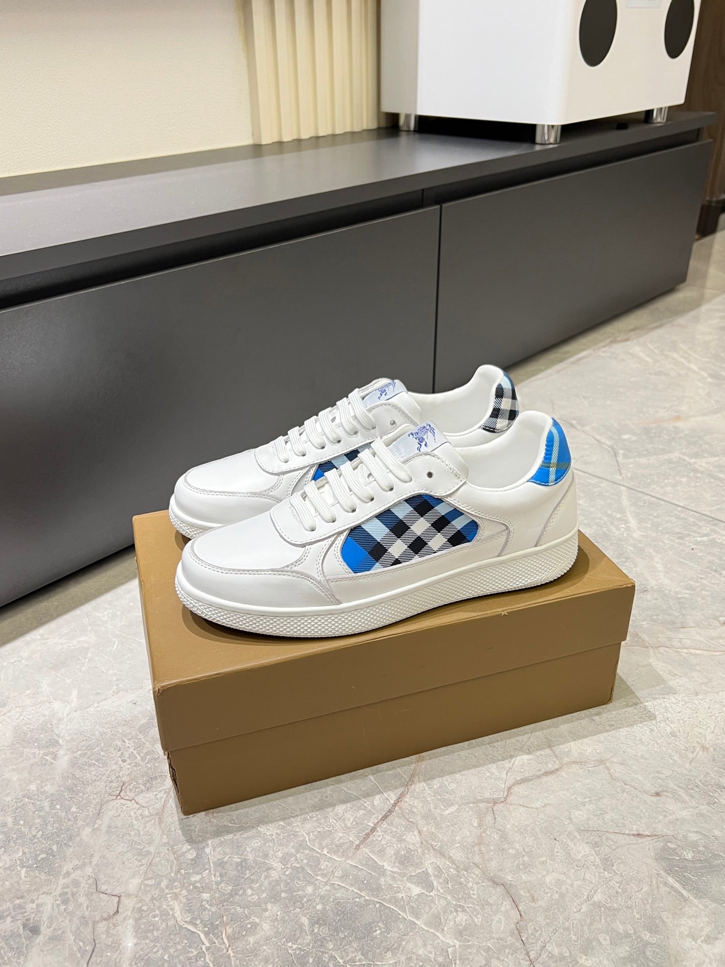 White Burberry sneakers side profile with blue leather and black check overlay