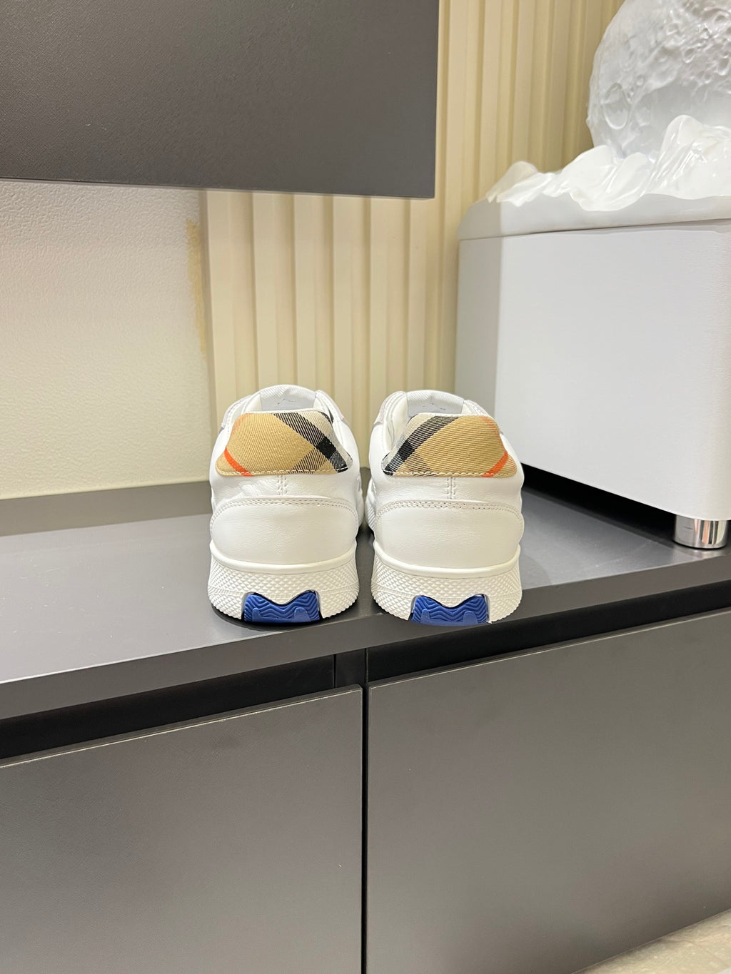 Back view of white Burberry check lace-up sneakers with blue heel tabs
