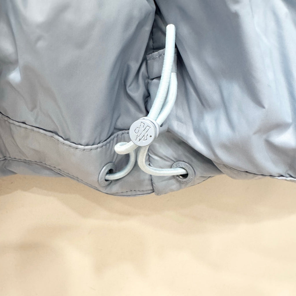 Light blue puffer jacket hem with gray drawstring toggles