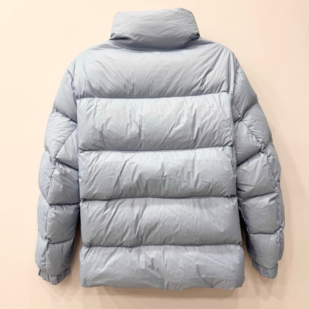 Light blue long puffer jacket back view with quilted panels and central zip