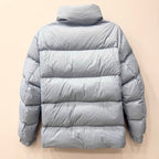 Light blue long puffer jacket back view with quilted panels and central zip