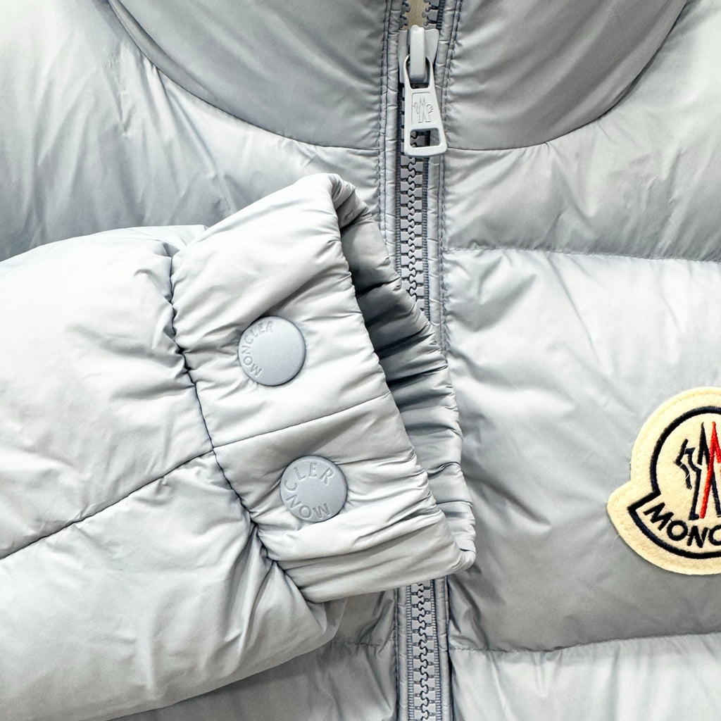 Light blue puffer jacket sleeve with snap-button cuff and quilted detail