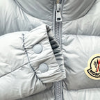 Light blue puffer jacket sleeve with snap-button cuff and quilted detail