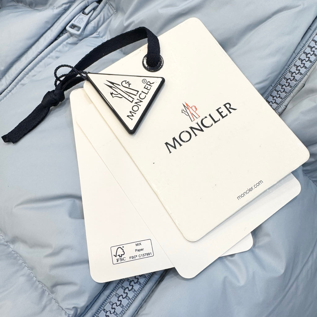 Light blue puffer jacket with hanging Moncler tags and retail label