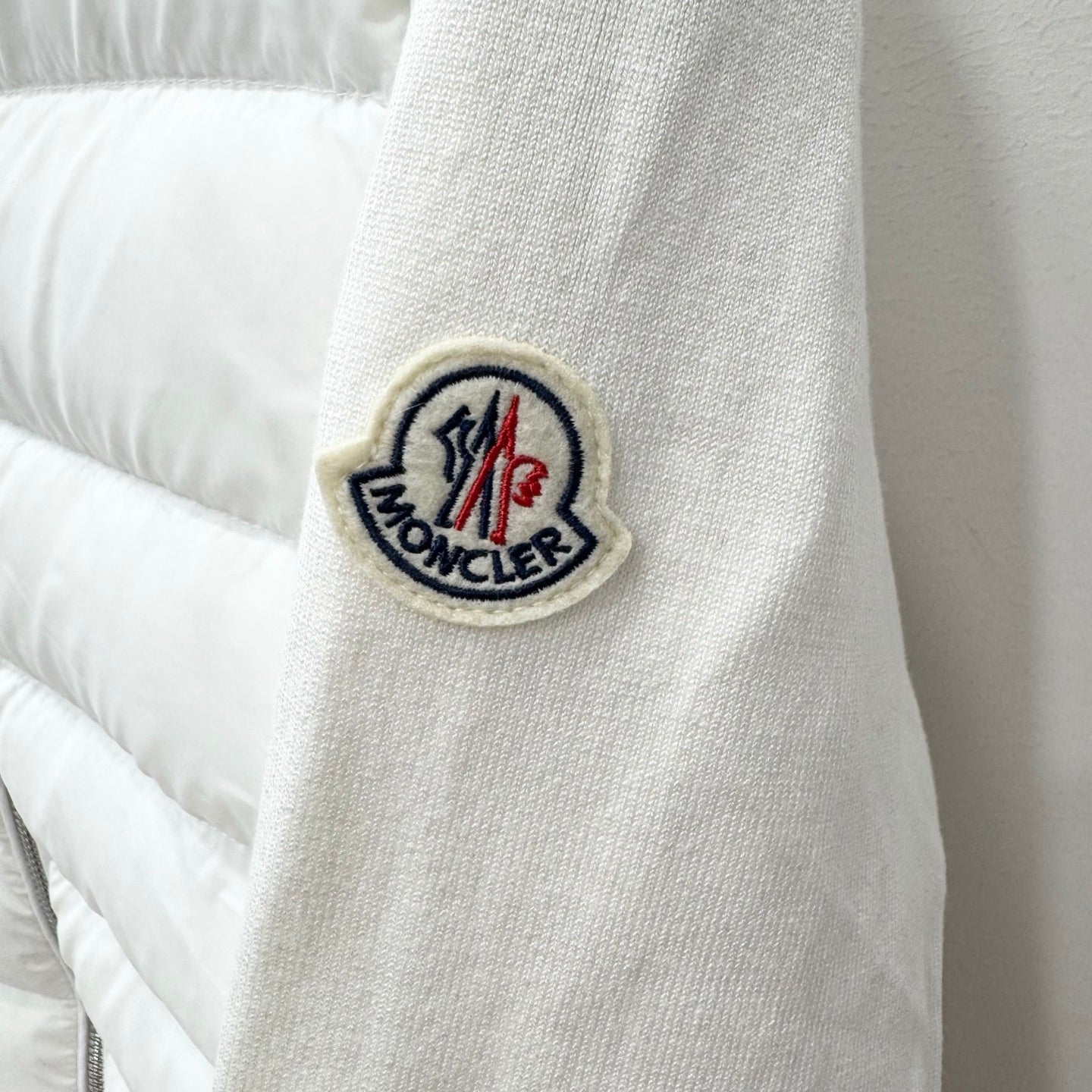 White puffer jacket sleeve with Moncler logo patch