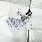 White puffer jacket with hang tags attached near the zip front