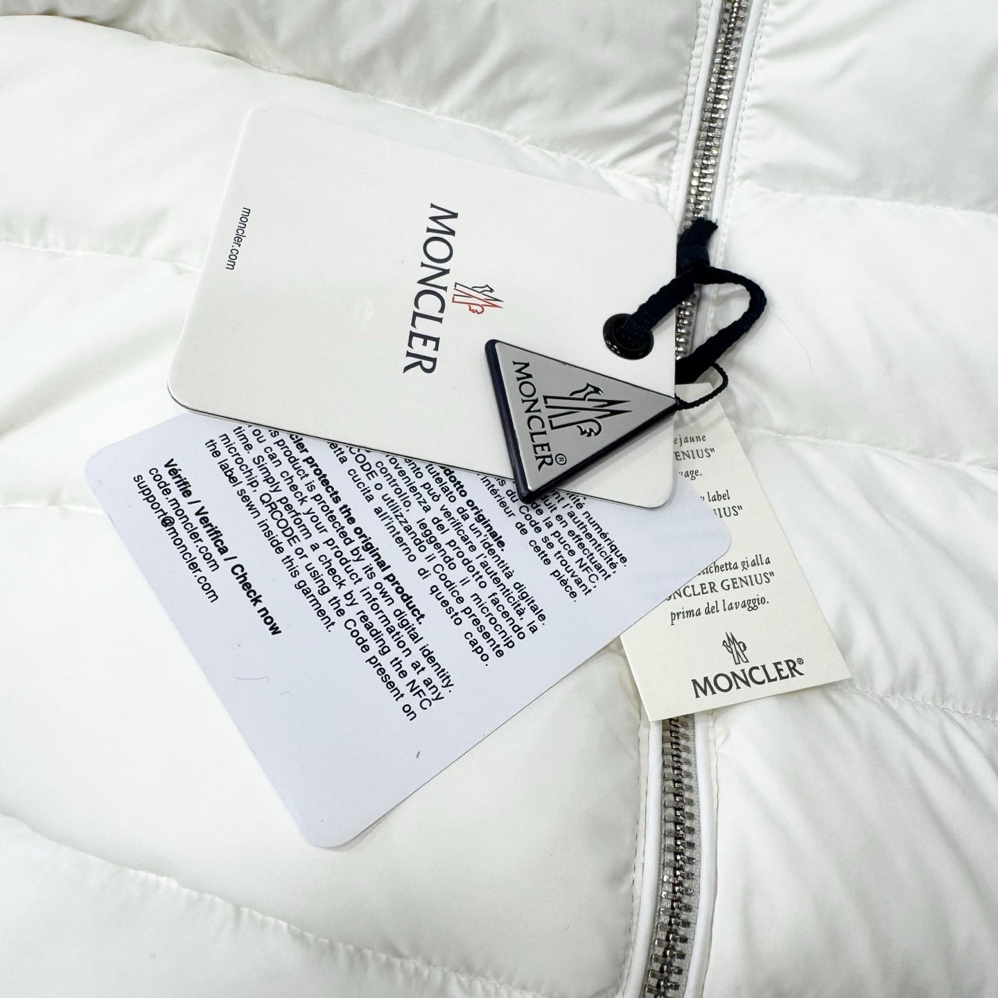 White puffer jacket with hang tags attached near the zip front