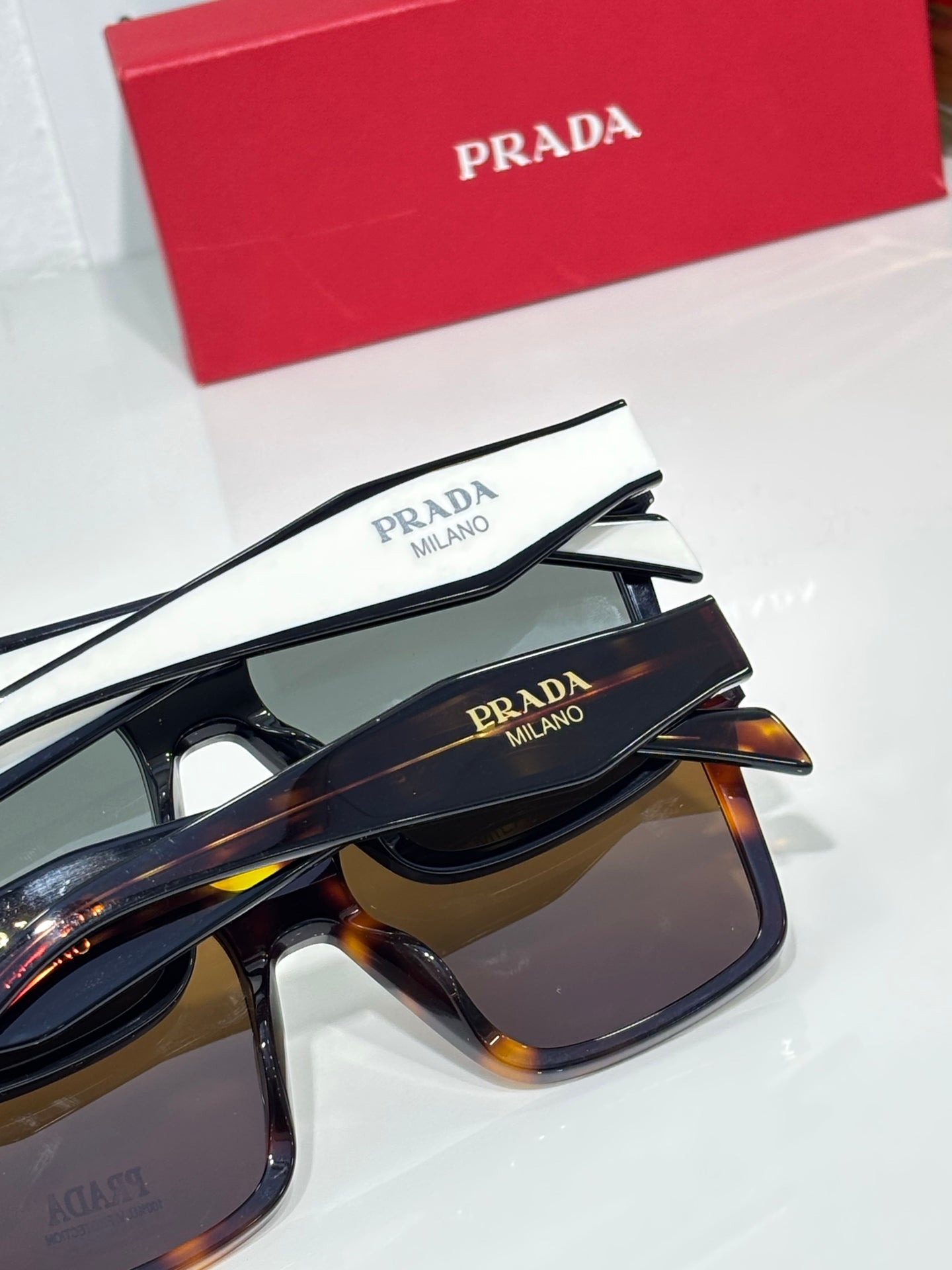 Prada sunglasses closeup with black, brown, and dark-tinted lenses