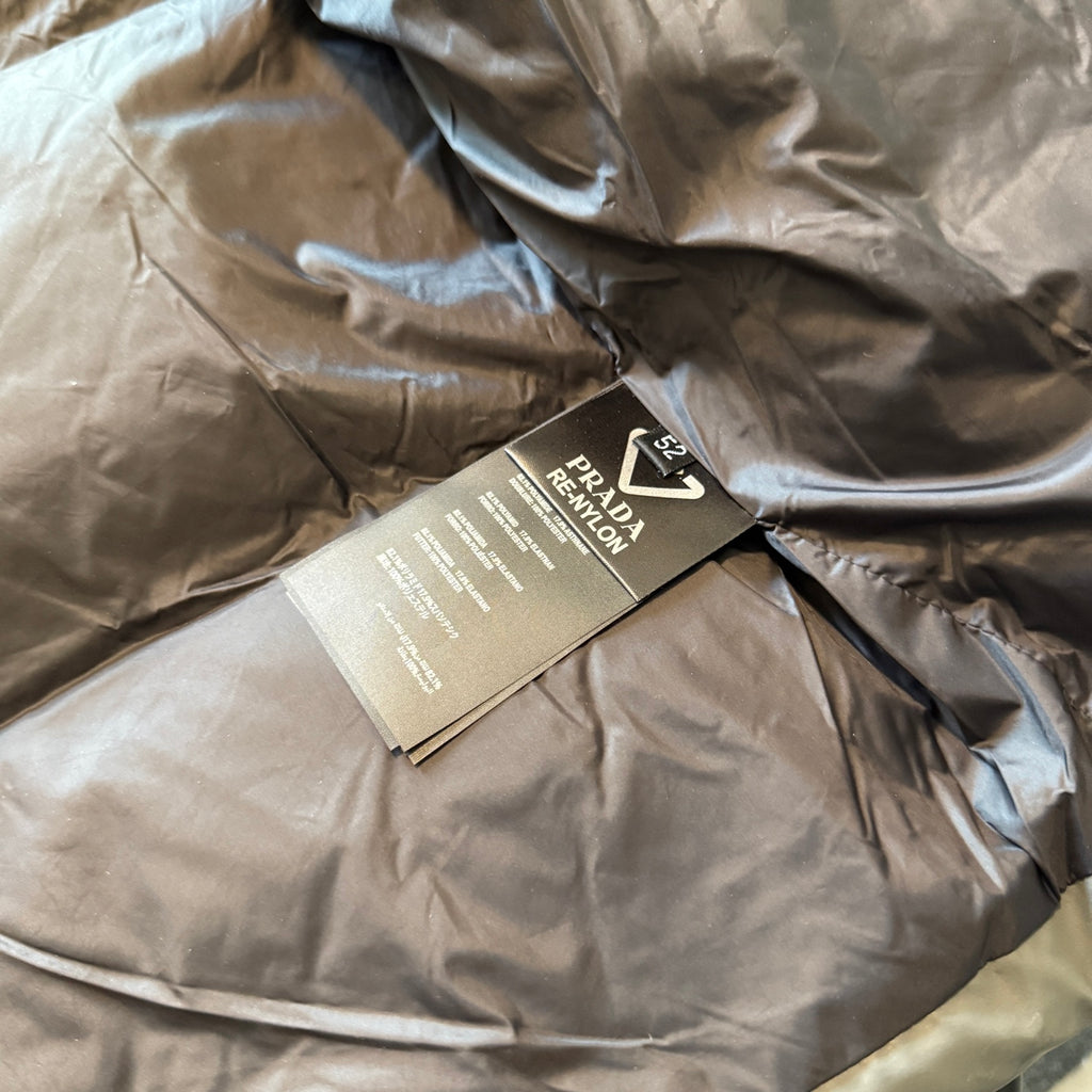 Prada puffer jacket with care tags over quilted lining, tan and dark
