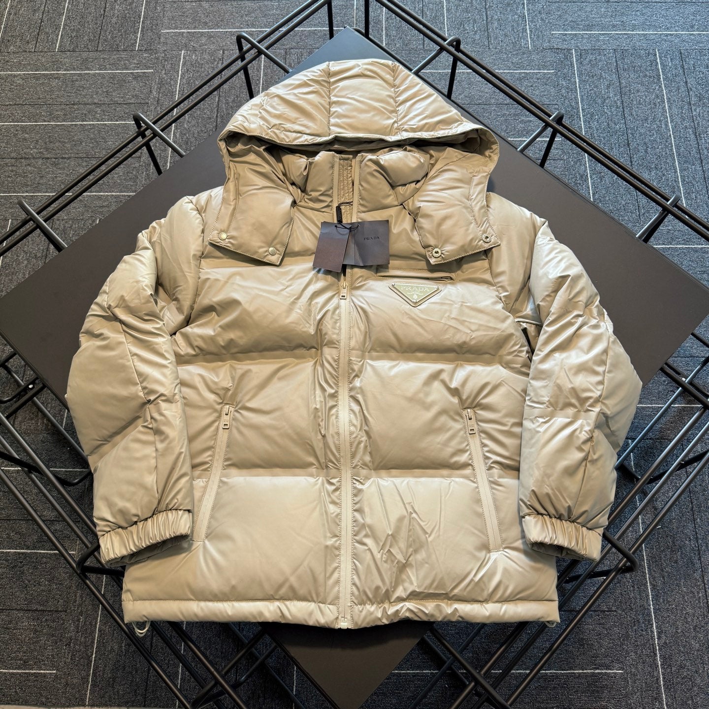 Beige hooded puffer jacket with full-length zipper and front patch pockets