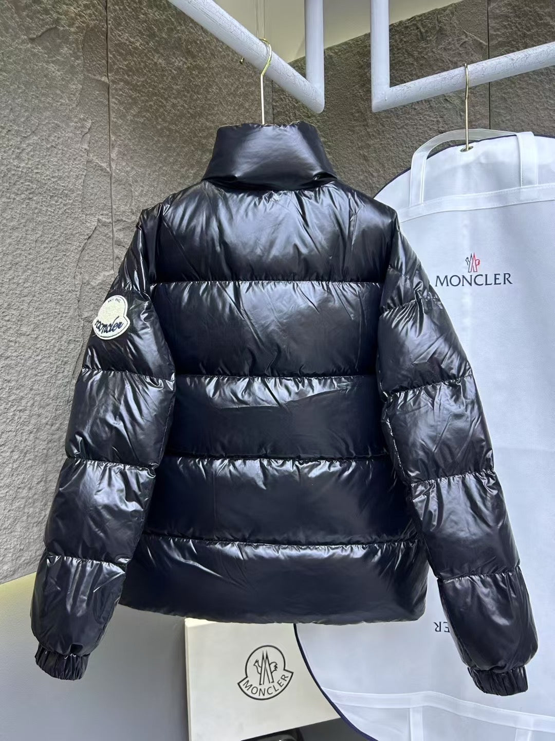 Dark blue puffer jacket with high neck and horizontal quilted stripes, back view.