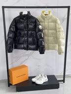 Black and cream puffer jackets with high necks and quilted panels.