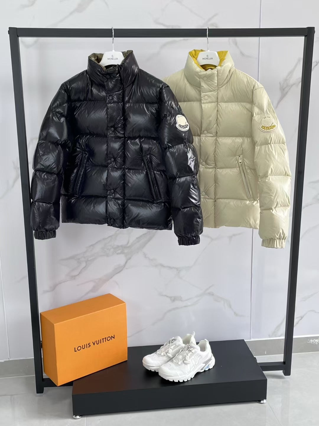 Black and cream puffer jackets with high necks and quilted panels.